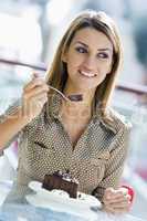 young woman eating chocolate cake