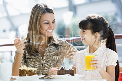 Mother and daughter eating cake