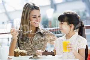 Mother and daughter eating cake