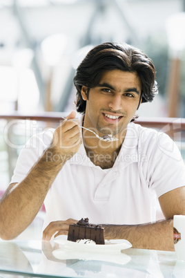 Young man having coffee and cake