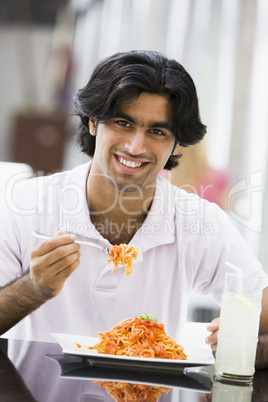 Young man eating pasta