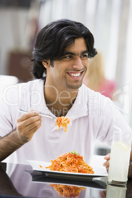 Young woman eating pasta