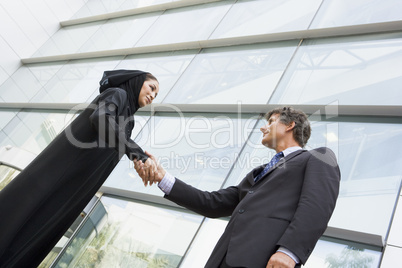 Two businesspeople in front of a tower building