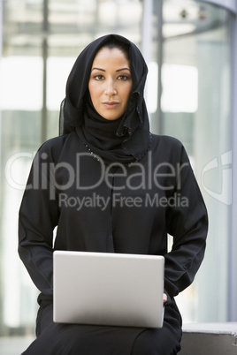 A Middle Eastern businesswoman using a laptop