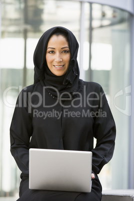 A Middle Eastern businesswoman using a laptop