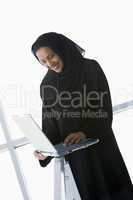 A Middle Eastern businesswoman using a laptop