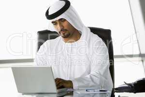 A Middle Eastern businessman using a laptop