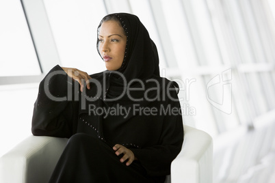 A Middle Eastern businesswoman gazing out of a window