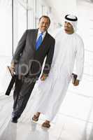 Two Middle Eastern businessmen walking down a corridor
