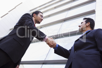 Two businessmen meeting outside office building