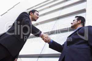 Two businessmen meeting outside office building