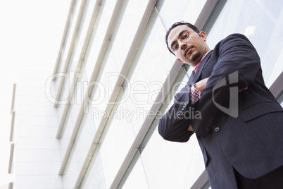 Businessman standing outside office block
