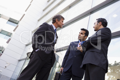 Group of businessmen talking outside office building