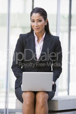 Businesswoman using laptop computer outside