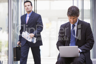 Businessman working at laptop outside