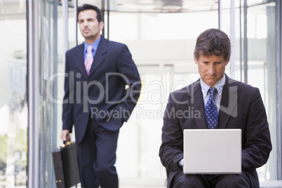 Businessman using laptop computer outside