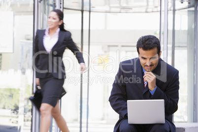 Businessman working at laptop outside