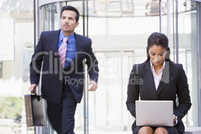 Businesswoman working at laptop outside