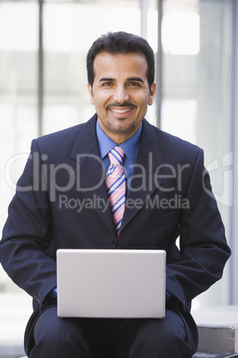 Businessman using laptop computer outside