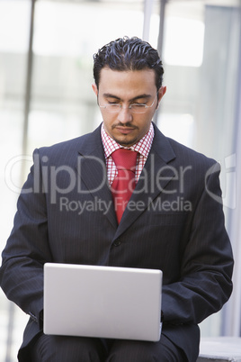 Businessman using laptop outside