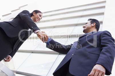 Business people shaking hands outside office