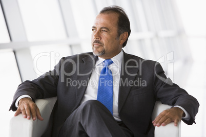 Businessman sitting in chair in lobby