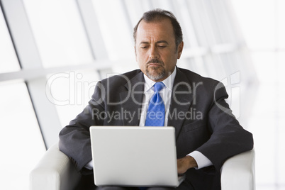 Businessman working on laptop in lobby