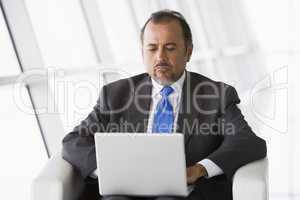 Businessman working on laptop in lobby
