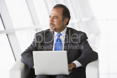 Businessman using laptop in lobby