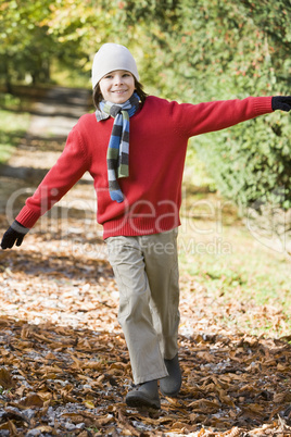 Young boy walking in the forrest in fall time