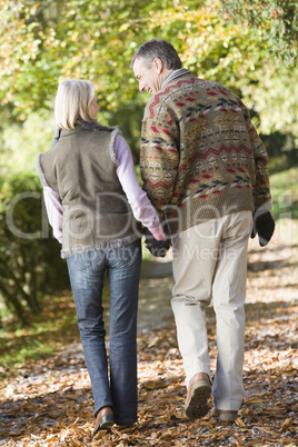 Older couple walking in the forrest in fall time
