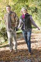 Older couple walking in the forrest in fall time