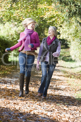 Mother and daughter walking in the forrest in fall time