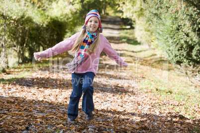 A young girl running on a forrest track  in fall time