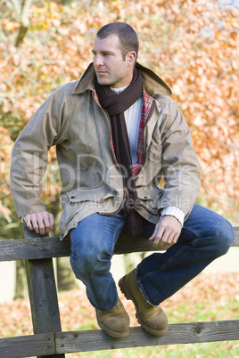 A man sitting on a fence