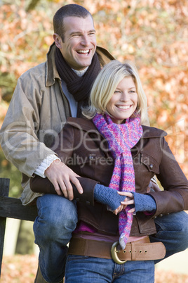 A young couple posing on a fence