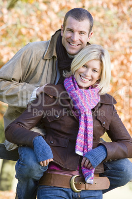 A young couple posing on a fence