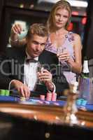 Ein junges Paar vor einem Roulettetisch