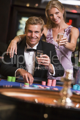 Ein junges Paar vor einem Roulettetisch