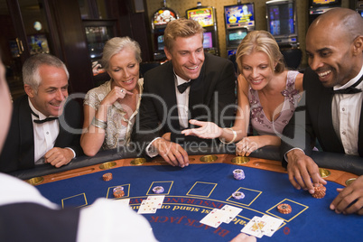 Drei Männer und zwei Frauen spielen Black Jack