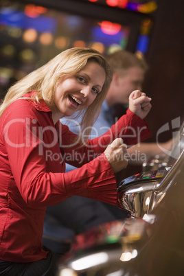 Eine blonde Frau in roter Bluse im Spielcasino