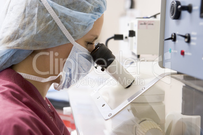 Embryologist using microscope