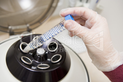 Embryologist putting sample into centrifuge