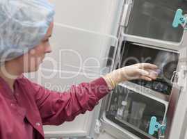 Embryologist putting sample into incubator