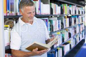 Senior man reading in a library