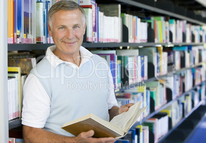 Senior man reading in a library