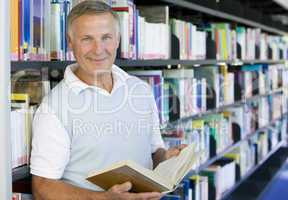 Senior man reading in a library