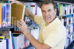 Man pulling a library book off shelf