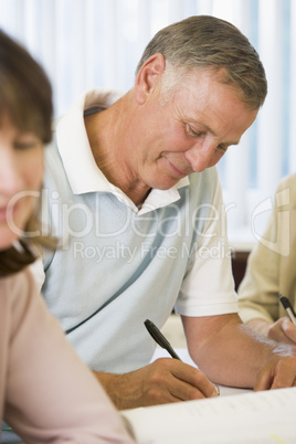 Senior man studying with other adult students