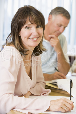 Middle aged woman studying with other adult students